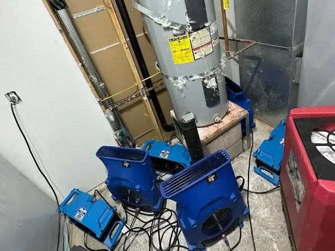 Air movers and a dehumidifier operate inside a water heater closet